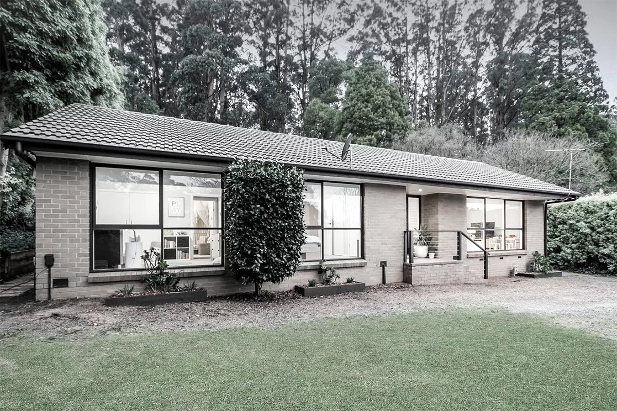 Contemporary house extension in Ferny Creek, featuring a white elevated structure designed to integrate with the forest surroundings — by MOA.studio