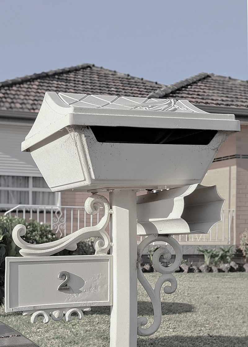 Image of an original letter box in front of a brick veneer post war home in Melbourne's northern suburbs. 