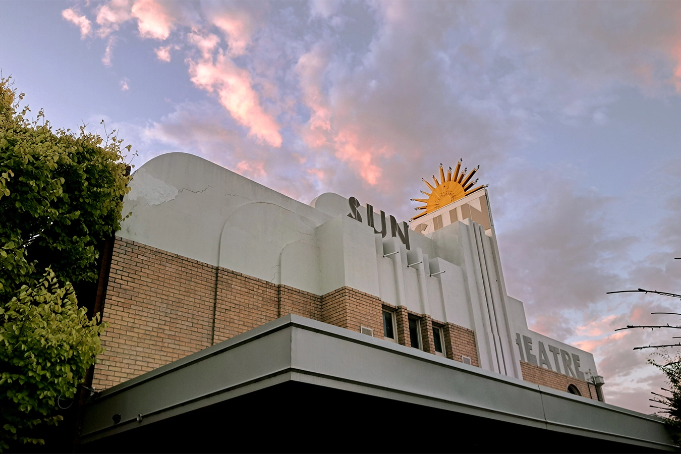 Photo of the Sun Theatre in Yarraville. Late in the evening with pick clouds in the sky. Photo by local architect Matthew Oczkowski.